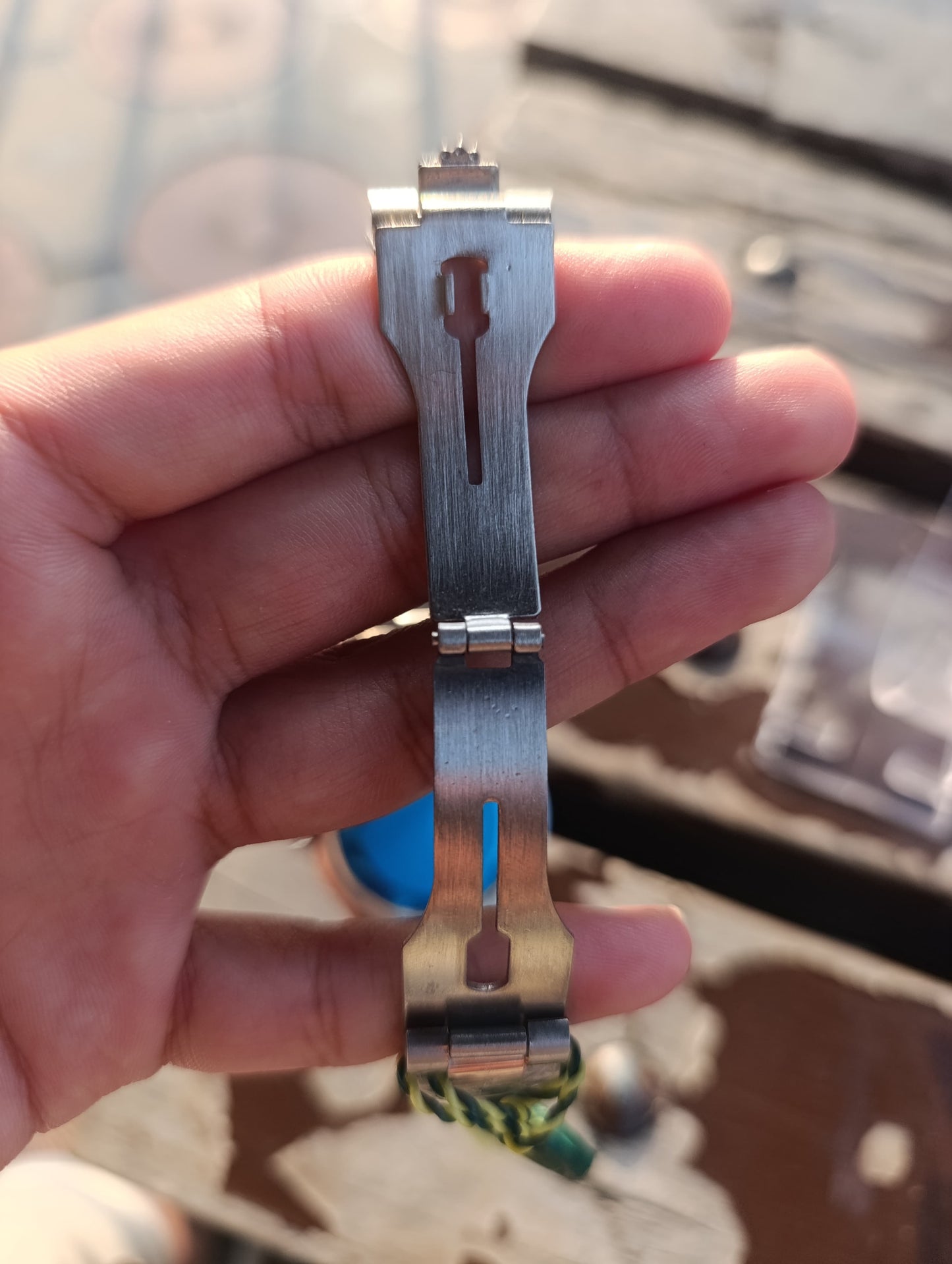 Metallic tool held in a hand with a blurred background